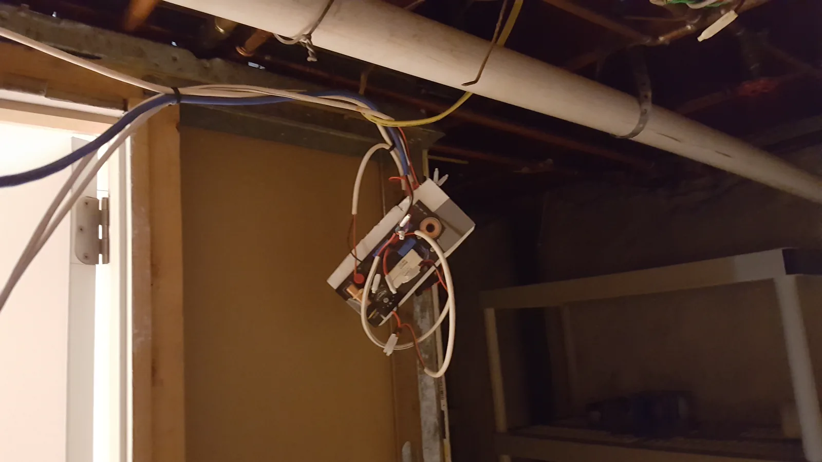 An in-wall speaker crossover mounted remotely after hitting a pipe