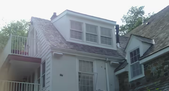 Outdoor audio speakers installed around a residential exterior