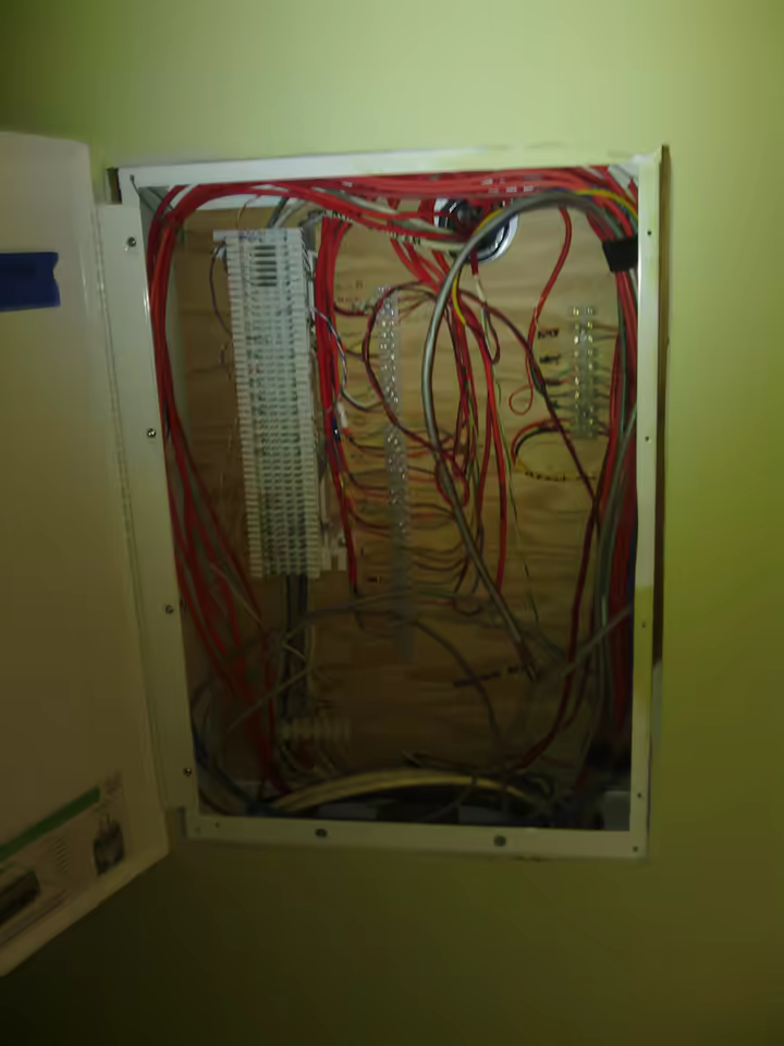 Open structured-wiring cabinet with low-voltage cabling and terminal blocks
